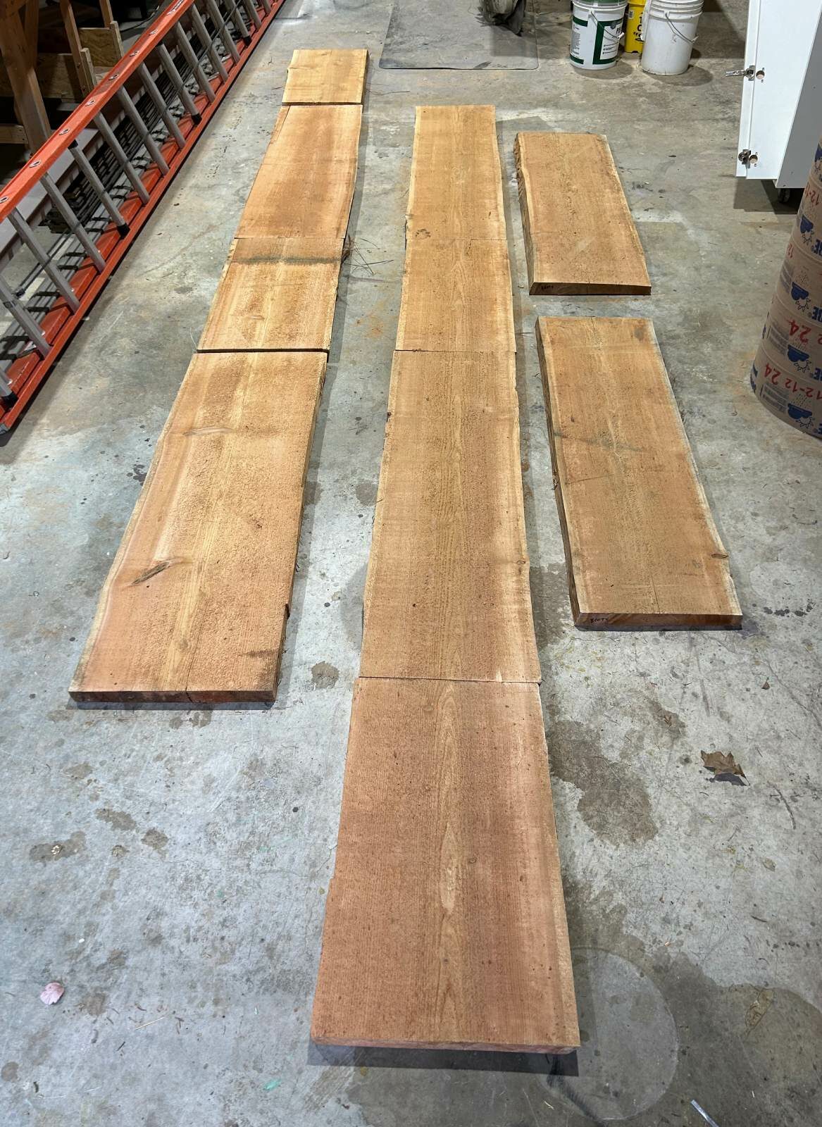 Rough-sawn cedar boards laid out in order on the shop floor