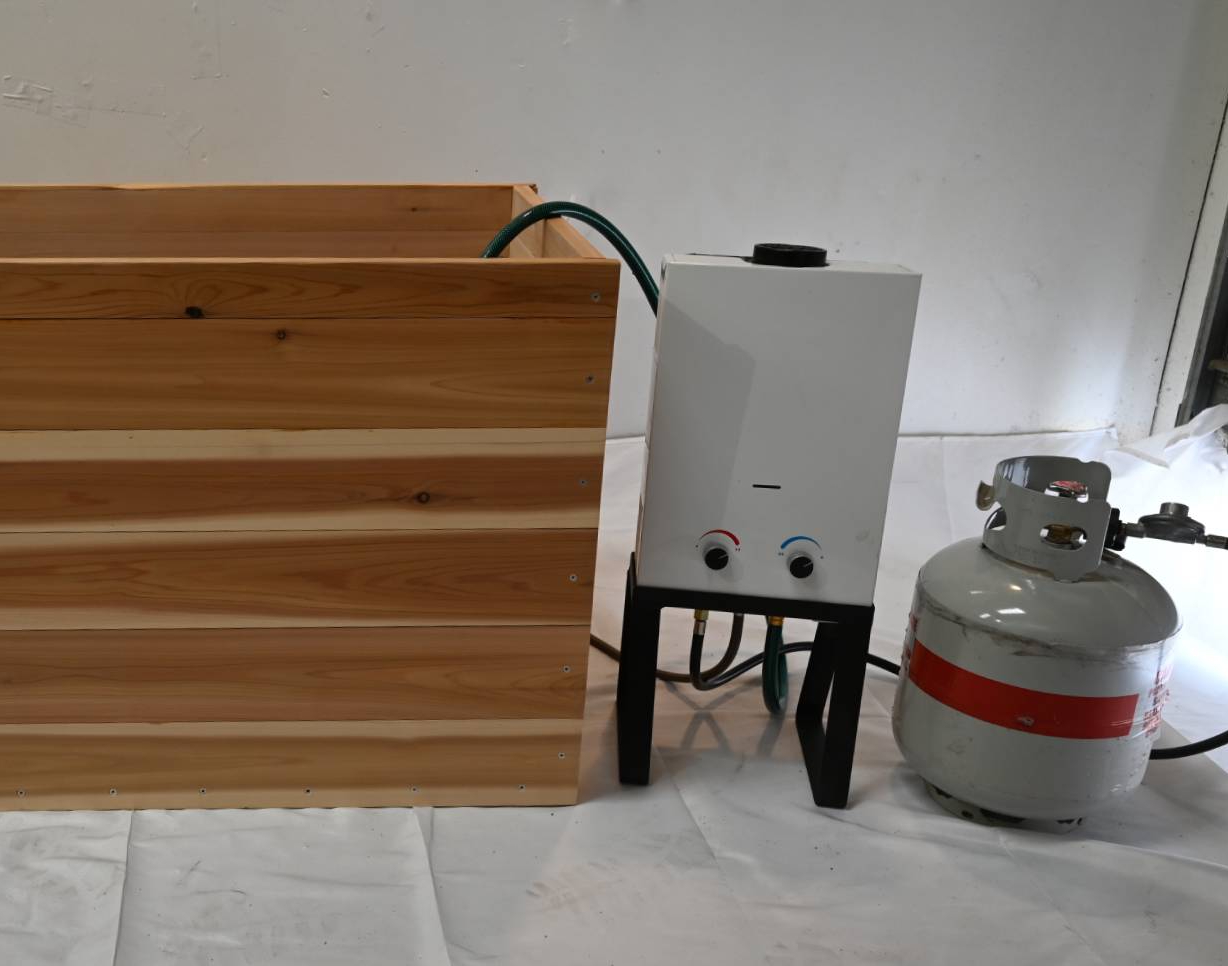Cedar soaking tub with portable tankless propane water heater and propane tank